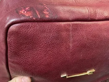 Bolso de piel granate con las esquinas peladas y sin color