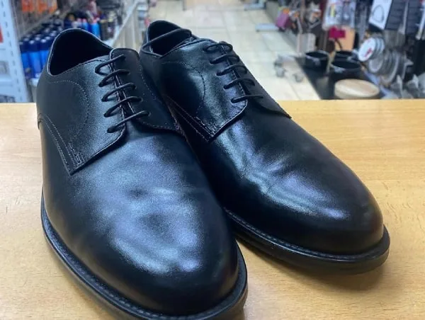 Los mismos zapatos negros limpios, teñidos y con brillo