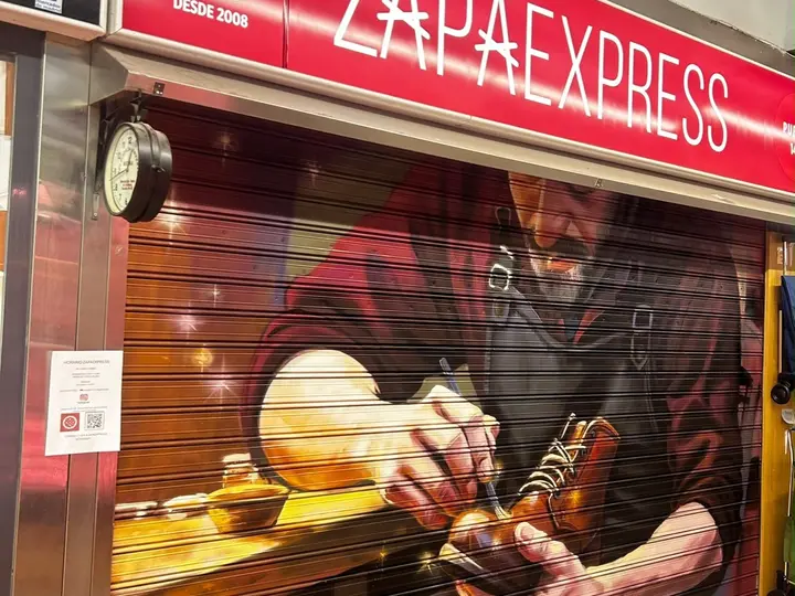 Persiana del puesto de Zapaexpress con el mural del zapatero y el rótulo DESDE 2008
