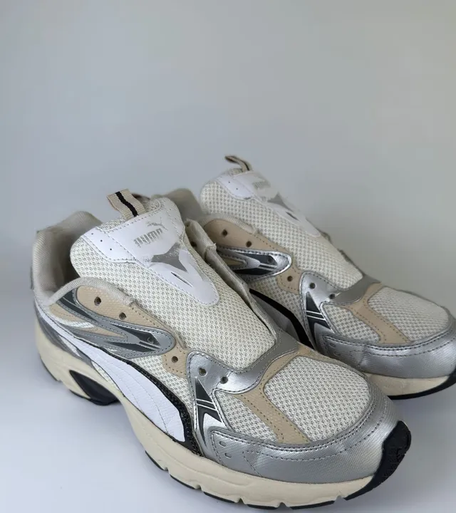 Zapatillas deportivas blancas y plateadas restauradas en Zapaexpress tras una limpieza profunda